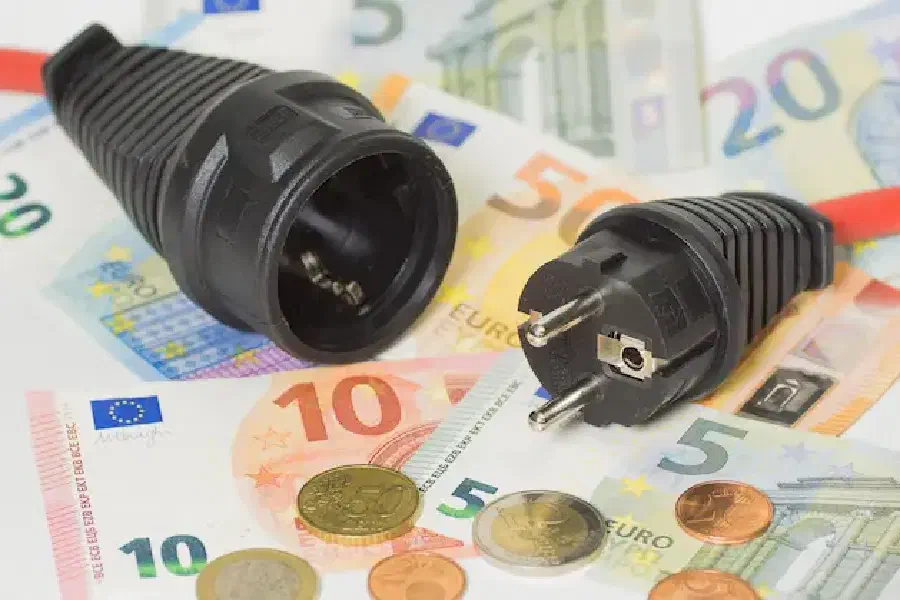 Muntgeld en briefjes liggen naast een stekker